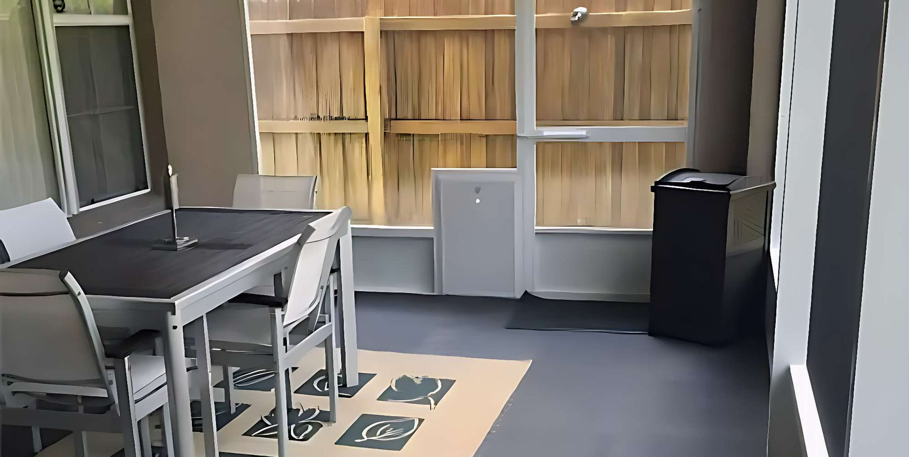 Modern patio setup with a table, chairs, and a pet door shows how to weatherproof a dog door