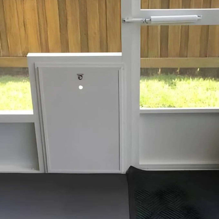 White puppy dog door with a locking panel installed in a screened enclosure providing secure access to a fenced backyard