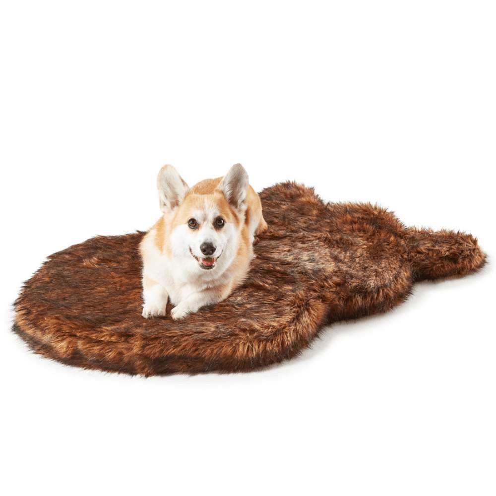 A Corgi is resting and looking happy on the Curve Brown Paw PupRug Faux Fur Orthopedic Dog Bed against a plain white background