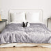 A French bulldog is lying on a bed covered with the Paw PupProtector™ Waterproof Throw Blanket - Ultra Soft Chinchilla