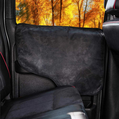 A black Paw PupProtector™ Car Door Guard (2 Pack) installed on a car door, with an autumn forest background seen through the window