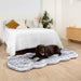 A chocolate labrador comfortably stretched out on a Paw PupRug™ Runner Faux Fur Memory Foam Dog Bed Ultra Plush Arctic Fox at the foot of a bed in a stylish bedroom setting