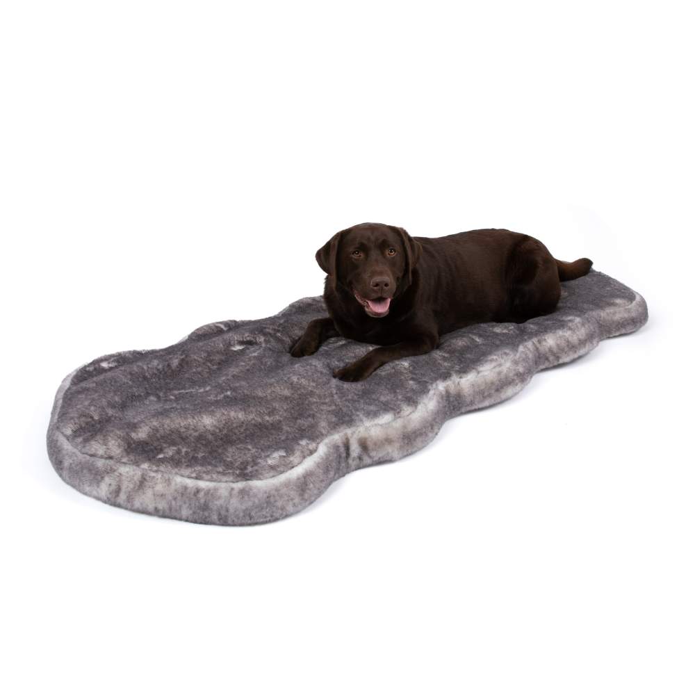 A chocolate labrador laying on a Paw PupRug™ Runner Faux Fur Memory Foam Dog Bed Ultra Soft Chinchilla against a plain white background