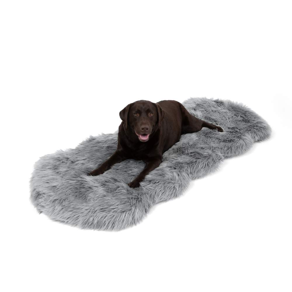 A chocolate labrador resting on a Paw PupRug™ Runner Faux Fur Memory Foam Dog Bed Charcoal Grey against a plain white background