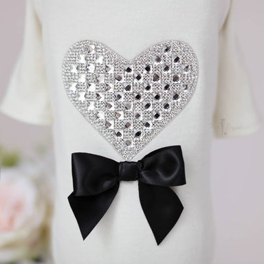 A close-up image of the Hello Doggie Oh My Heart Dog Tee showcases the intricate details of the crystal heart and black bow design
