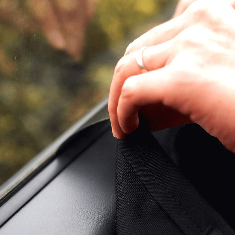 A close-up of a hand attaching the Paw PupProtector™ Car Door Guard (2 Pack) to a car door using Velcro strips