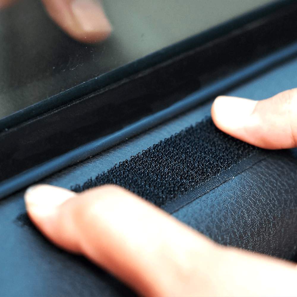 A close-up of a hand pressing the Velcro strip of the Paw PupProtector™ Car Door Guard (2 Pack) firmly onto the car door frame