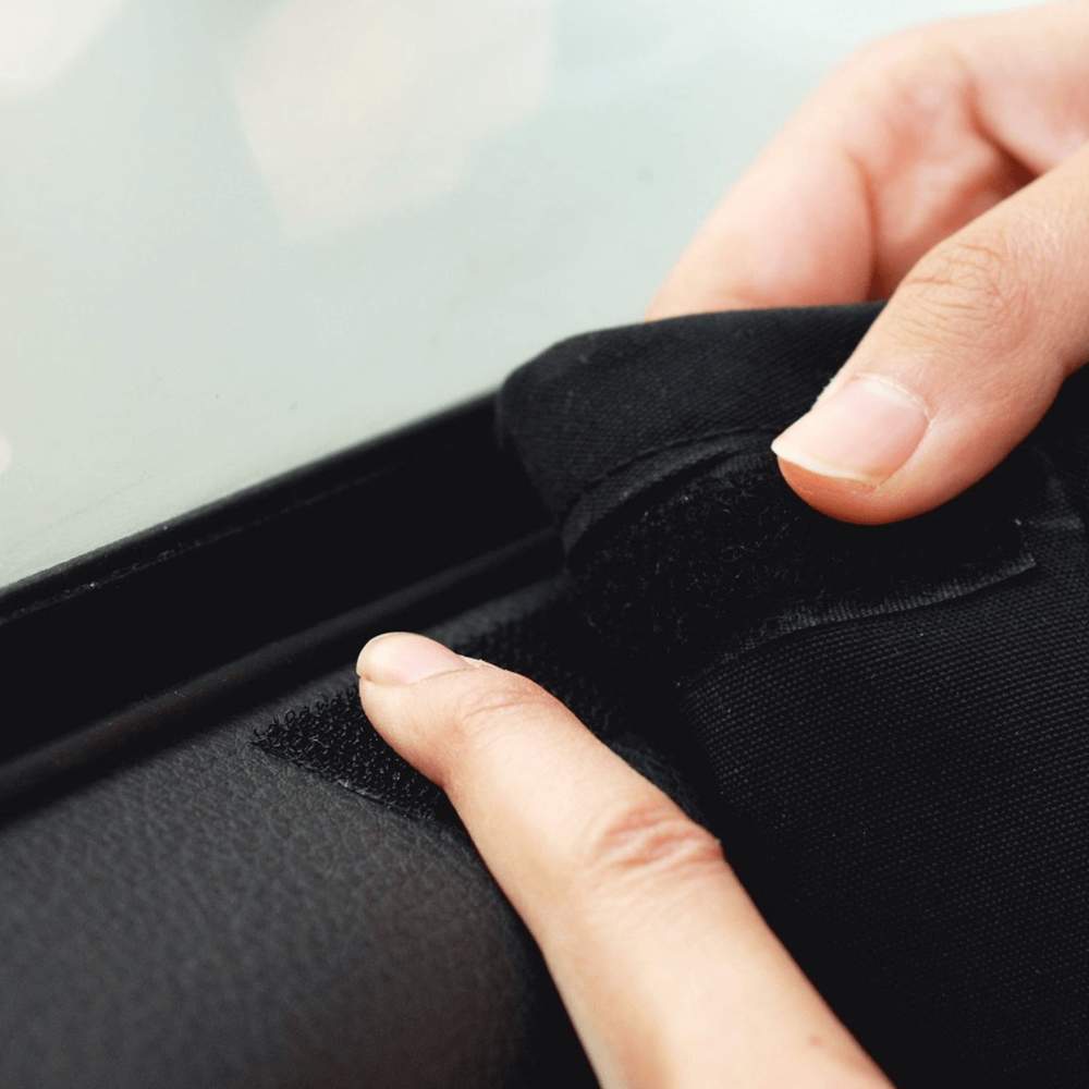 A close-up of a hand securing the Velcro strip of the Paw PupProtector™ Car Door Guard (2 Pack) to a car door frame for a snug fit