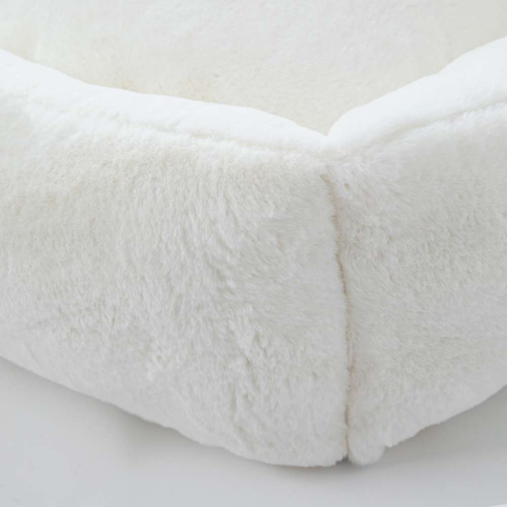 A close-up of the Hello Doggie Big Baby Bed in natural color reveals the bed's soft, furry surface and well-crafted seams