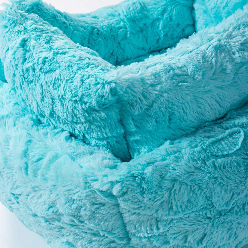 A close-up of the soft, plush material of the Hello Doggie Cuddle Dog Bed in a vibrant aqua color