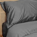 A close-up shot of a pillow and bedding in a dark grey color, showcasing the Paw PupSheets™ Hair Resistant, Antimicrobial, & Cooling Duvet Cover and Sheet Set Bundle - Graphite