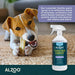 A dog chewing a bone on a rug, with the ALZOO Enzyme-Based Stain & Odor Remover Spray 32oz - Lavender Vanilla prominently displayed