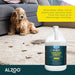 A dog near a soiled carpet, with the ALZOO Enzyme-Based Stain & Odor Remover - Citrus Vanilla prominently displayed