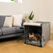 A dog relaxes in a black wire crate with a grey padded interior, from the Paw Upgrade Your Dog Crate Kit - Charcoal Grey