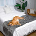 A golden retriever is lounging on a bed with the Paw PupProtector™ Waterproof Bed Runner - Charcoal Grey Pet Blankets