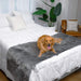 A golden retriever is lying on a bed covered with the Paw PupProtector™ Waterproof Bed Runner - Charcoal Grey Dog Blanket