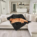 A golden retriever is peacefully lying on a couch covered with the Paw PupProtector™ Short Fur Waterproof Throw Blanket - Midnight Black in a modern living room