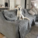 A golden retriever sits on a grey sofa adorned with the Paw PupProtector™ Waterproof Throw Blanket - Charcoal Grey Dog Blankets