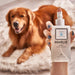 A hand holding a bottle of Paw Marlie Mist Pet Odor Eliminator Spray with Essential Oils - Fres & Unscented with a happy Golden Retriever in the background