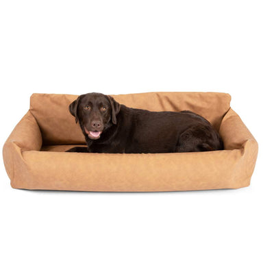 A large brown dog is lying comfortably in the Paw PupProtector™ Faux Leather Memory Foam Dog Car Bed - Camel