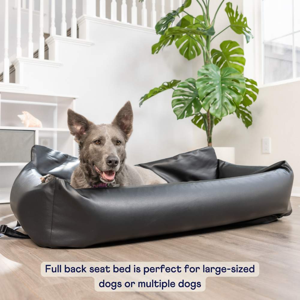 A large dog is comfortably lying in a Paw PupProtector™ Faux Leather Memory Foam Dog Car Bed - Black Full Back Seat Portable Dog Bed