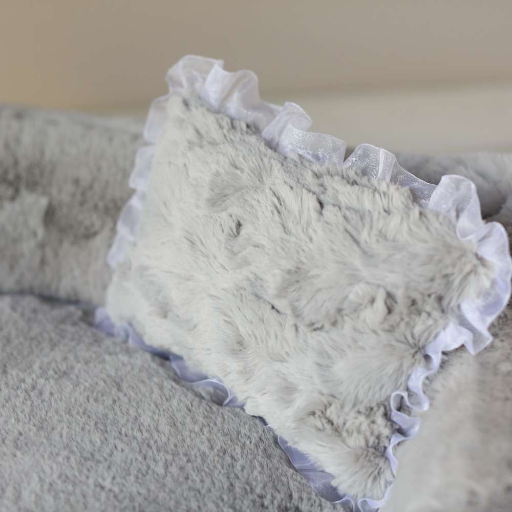 An image provides a detailed look at the gray pillow with ruffles, a component of the Hello Doggie Divine Dog Bed in gray