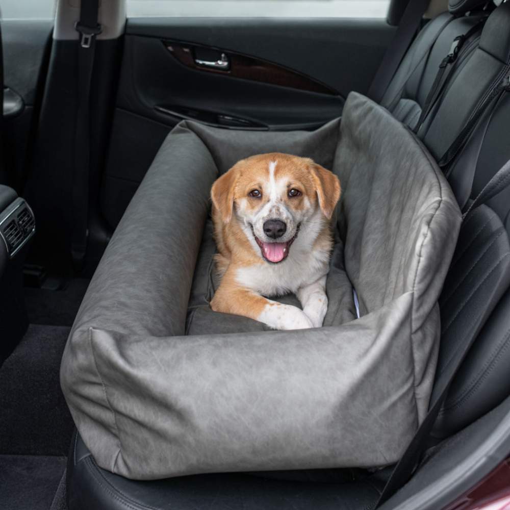 Another dog is comfortably lying in the Paw PupProtector™ Faux Leather Memory Foam Dog Car Bed - Slate Gray Doggy Bed, in the back seat of a car