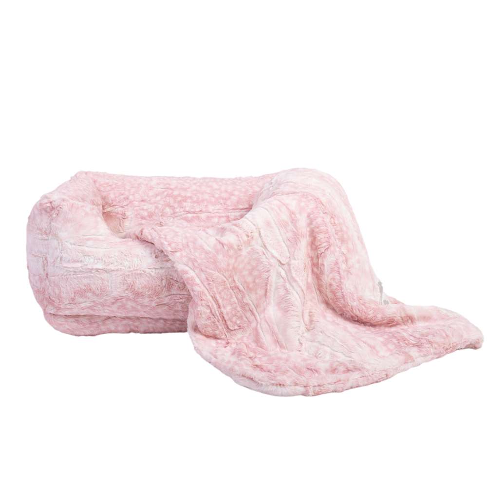 A plush, pink Hello Doggie Cashmere Dog Bed with a soft, fur-like texture, featuring a cozy blanket draped over the side