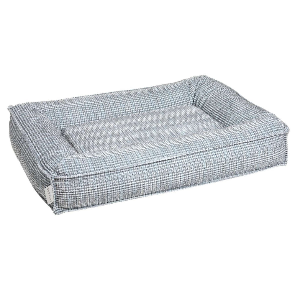 Arctica Bowsers Divine Futon Dog Bed featuring a gray plaid design with supportive padded edges for dogs