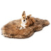 A small dog is lying comfortably on a Curve Sable Tan Paw PupRug Faux Fur Orthopedic Dog Bed