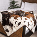 A small dog is resting on a bed covered with the Paw PupProtector™ Waterproof Throw Blanket - Brown Faux Cowhide Best Dog Blankets