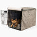 A small dog lies inside a black wire crate with a grey padded cover and lining from the Paw Upgrade Your Dog Crate Kit - Charcoal Grey