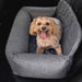 A small dog with a big smile sits in a Paw PupProtector™ Memory Foam Dog Car Bed - Double Car Seat in the back seat of a car, looking up