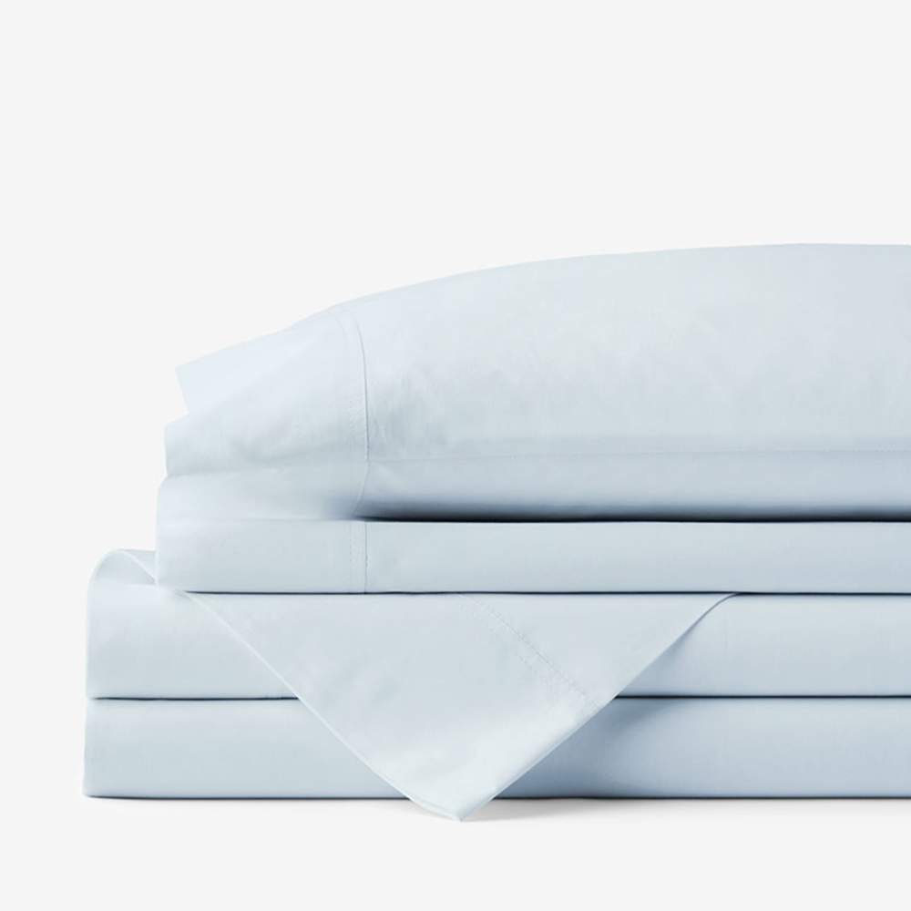 A stack of folded bedding highlights the Paw PupSheets™ Hair Resistant, Antimicrobial, & Cooling Duvet Cover and Sham Set - Sky Blue