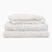 A stack of three fluffy white blankets from the Paw Upgrade Your Dog Crate Kit - Polar White