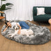 A woman relaxes with her dog on the Charcoal Grey Paw PupCloud™ Human-Size Faux Fur Memory Foam Dog Bed