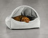 Bowsers Canopy Dog Bed is a light gray covered bed with a brown dog tucked inside, resting its head over the front edge
