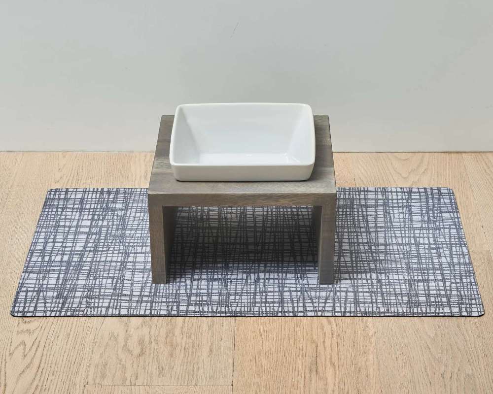 Bowsers Gourmet Placemat For Artisan Dog Feeder under a raised wooden dog bowl stand with a white ceramic dish on light wood flooring