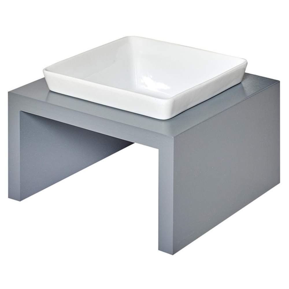 Bowsers Moderno Single Wood Feeder is pictured from a side perspective with a square white ceramic bowl atop a minimalist grey wooden base