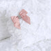 Close-up of a luxurious Hello Doggie Enchanted Nights Dog Bed featuring a white fluffy cushion adorned with a soft pink satin bow with a sparkling crystal centerpiece
