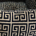 Close-up view of the fabric pattern on the Hello Doggie Obsidian Dog Bed, showcasing the intricate black and tan Greek key design