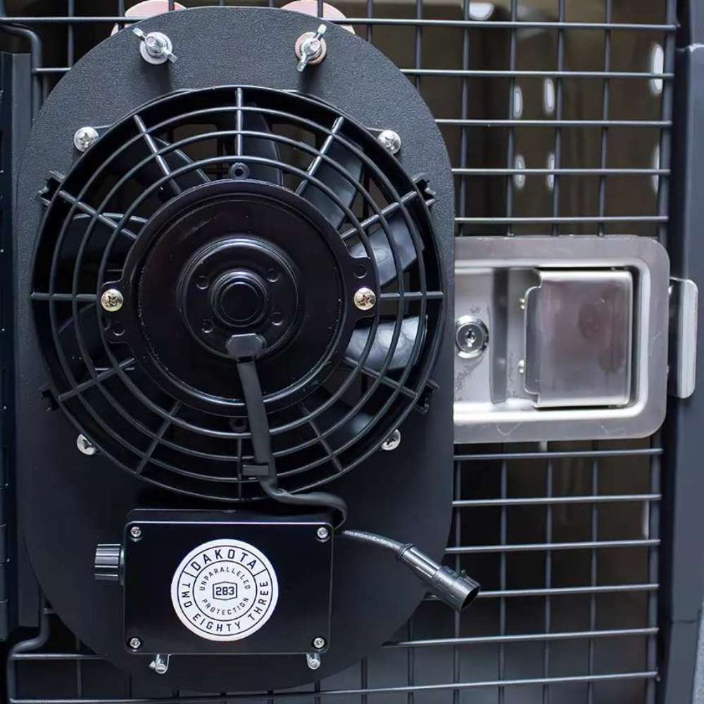 Dakota 283 Dog Crate Ventilation Fan mounted on the outside of a crate door, with a protective grille covering the spinning fan