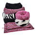 Pile of cozy Bowsers The Muffy Dog Bed options in pink, zebra print, and black, stacked with matching mats