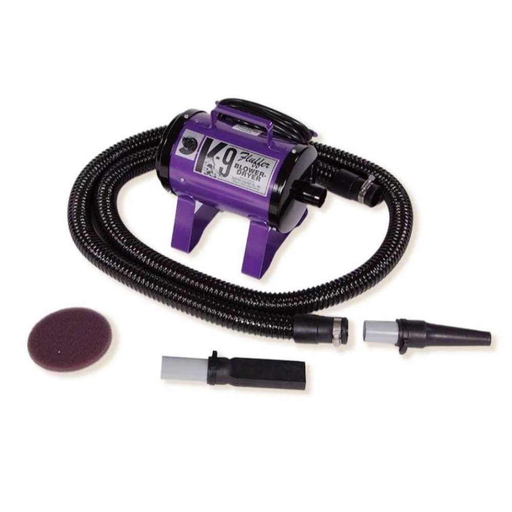 Purple K-9 Fluffer Dryer with a long coiled hose and grooming tools is placed neatly on a white surface