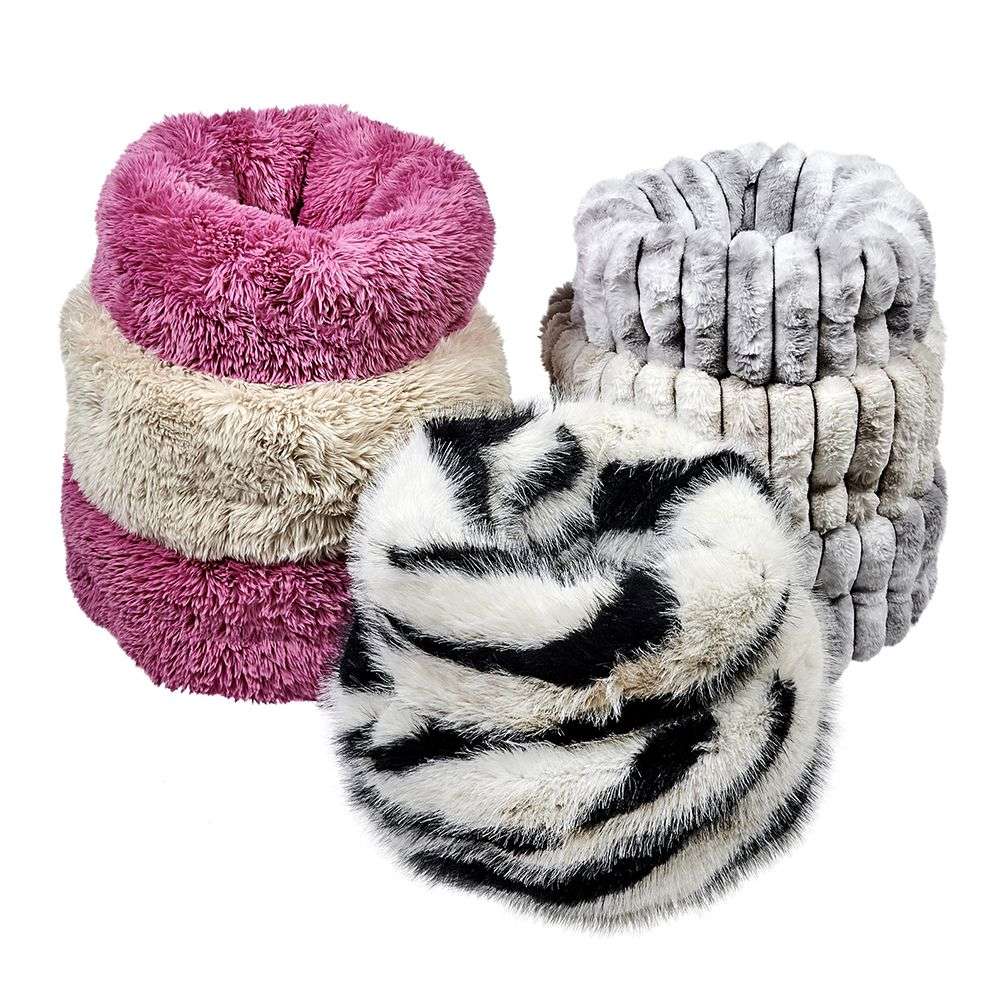 Several stacked Bowsers The Muffy Dog Bed in fluffy fabrics, including striped and solid designs