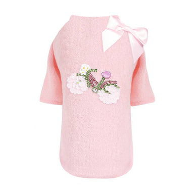 The Hello Doggie Bicycle Dog Sweater is a light pink sweater adorned with a decorative bicycle design and a bow near the collar