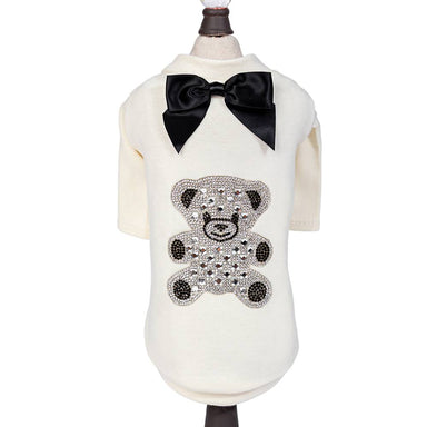 The Hello Doggie Teddy Bow Tee is displayed on a mannequin, highlighting the black satin bow and crystal teddy bear design on the cream-colored tee