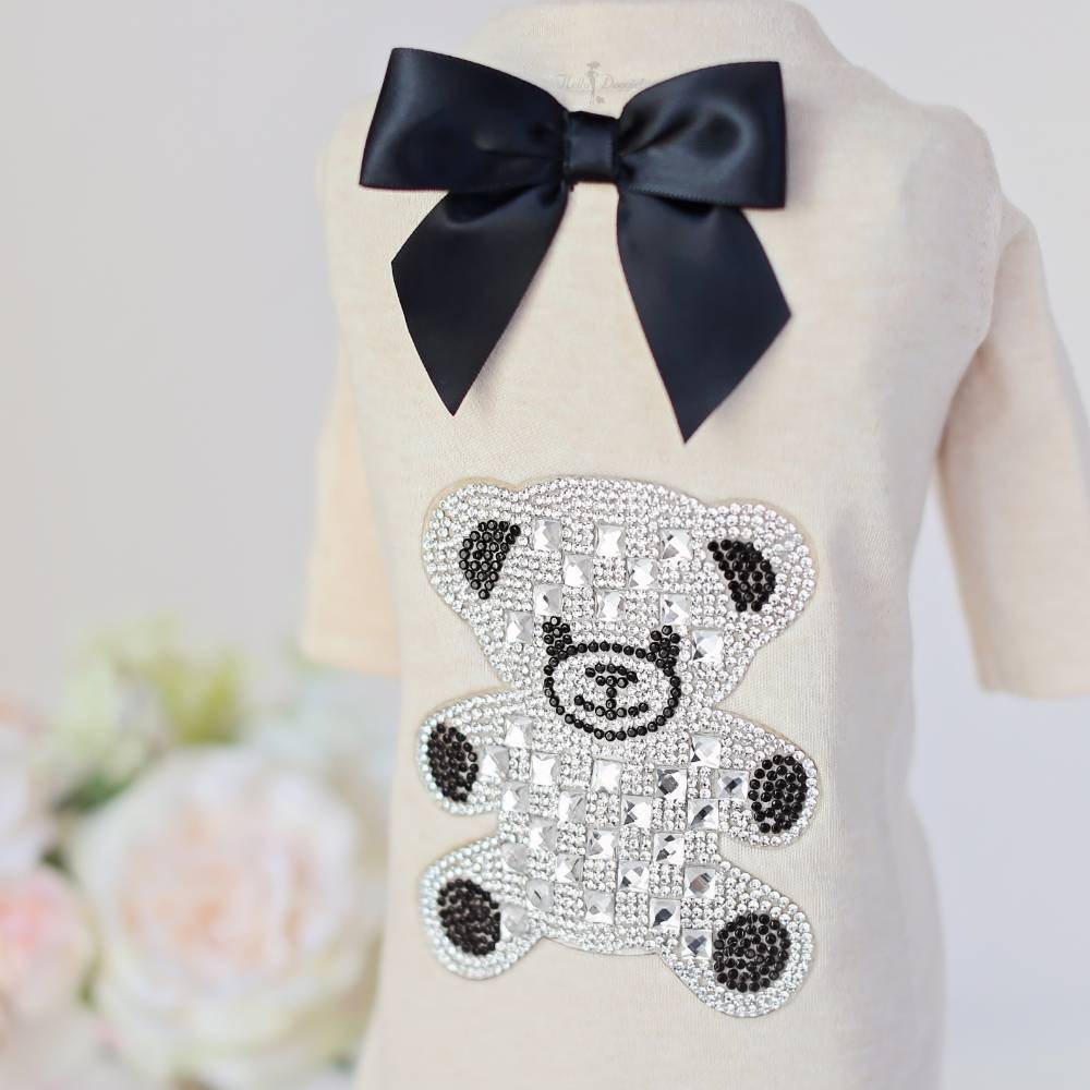 The Hello Doggie Teddy Bow Tee showcases a detailed view of the sparkling crystal teddy bear embellishment on the cream-colored fabric