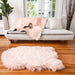The Paw PupProtector™ Waterproof Throw Blanket - Blush Pink is displayed on a sofa, with an additional matching rug in front