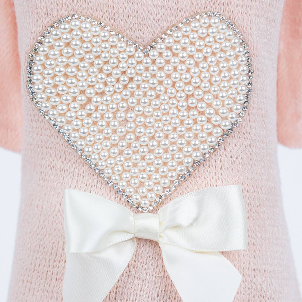 The detailed close-up of the Hello Doggie Pearl Heart Dog Sweater in peach color showcases the intricate pearl heart design with a white bow at the base